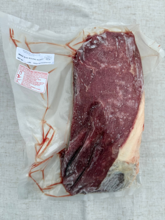 Vacuum-sealed package of raw meat on a textured surface