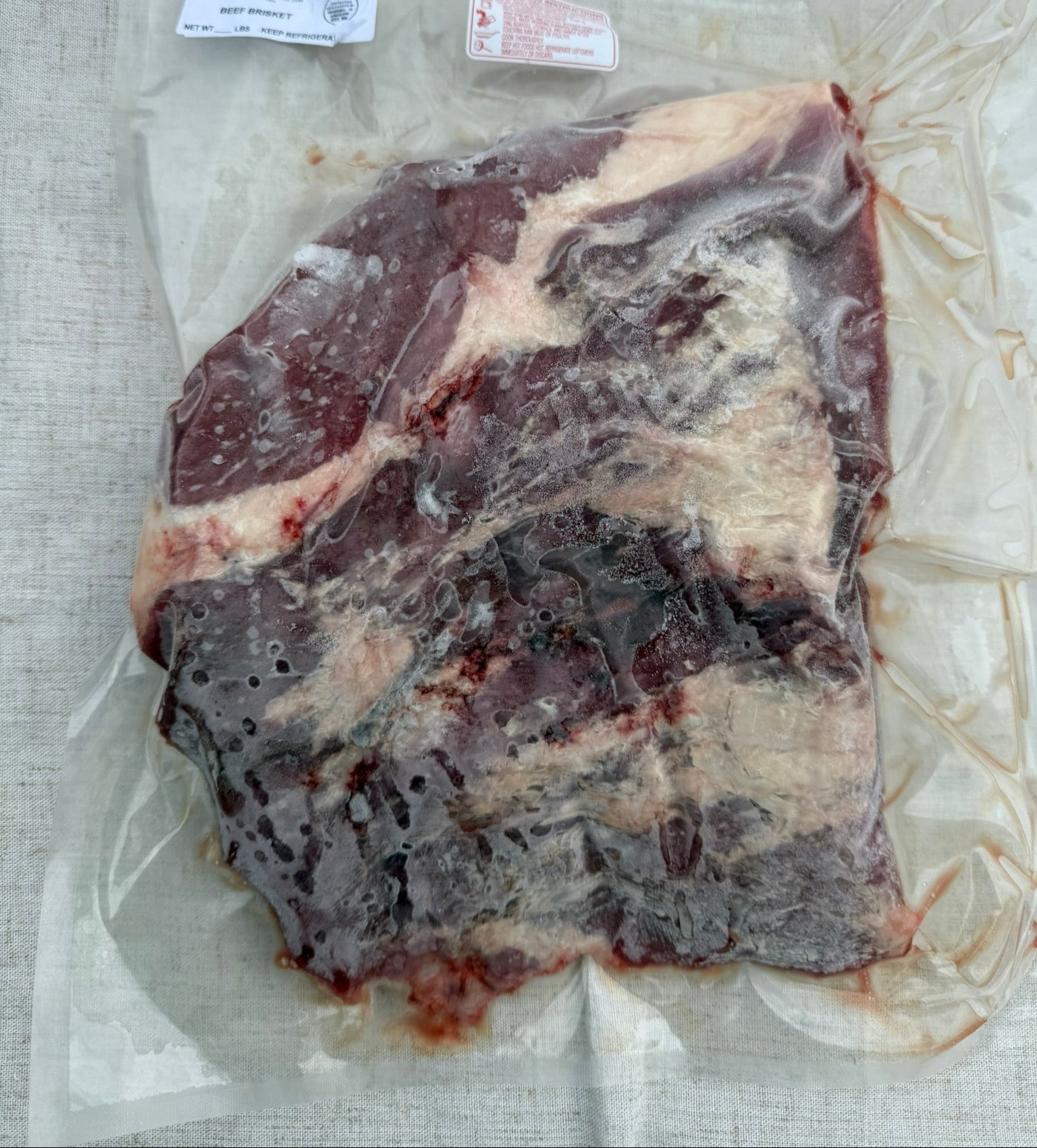 Raw meat in a vacuum-sealed package on a textured surface