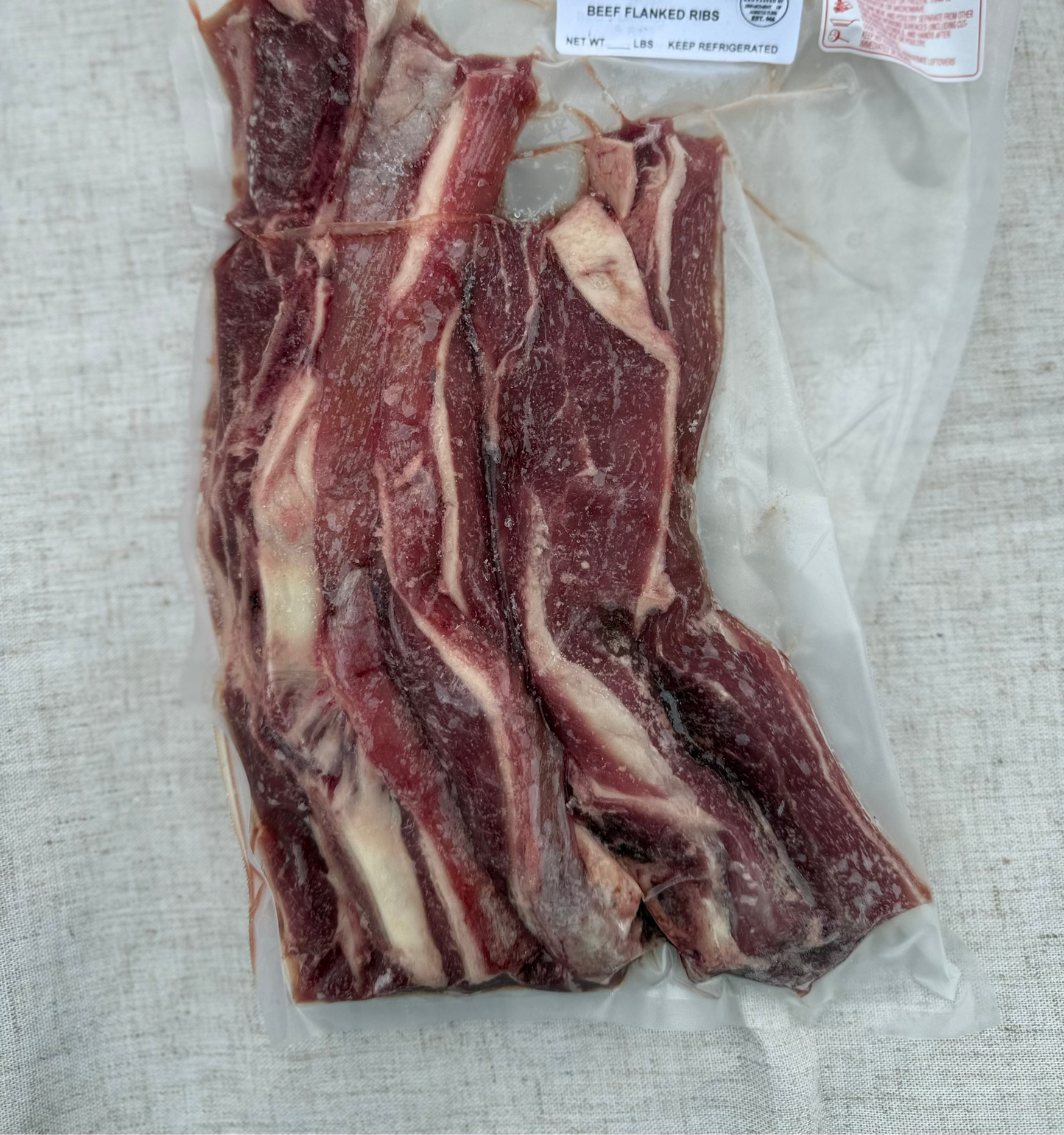 Packaged beef flanks rib on a textured surface